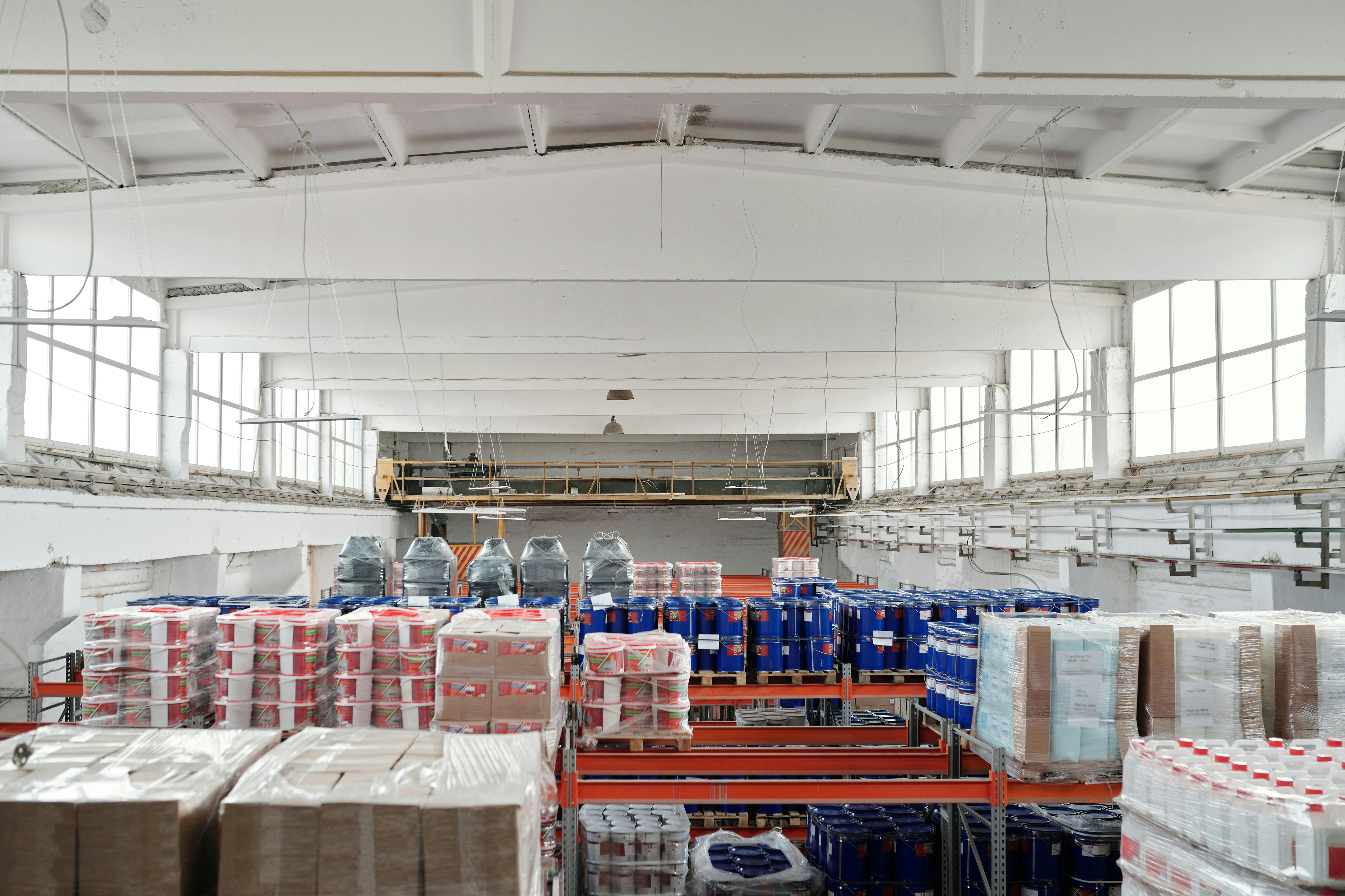 Warehouse interior with stacked product on industrial shelving and overhead lighting
